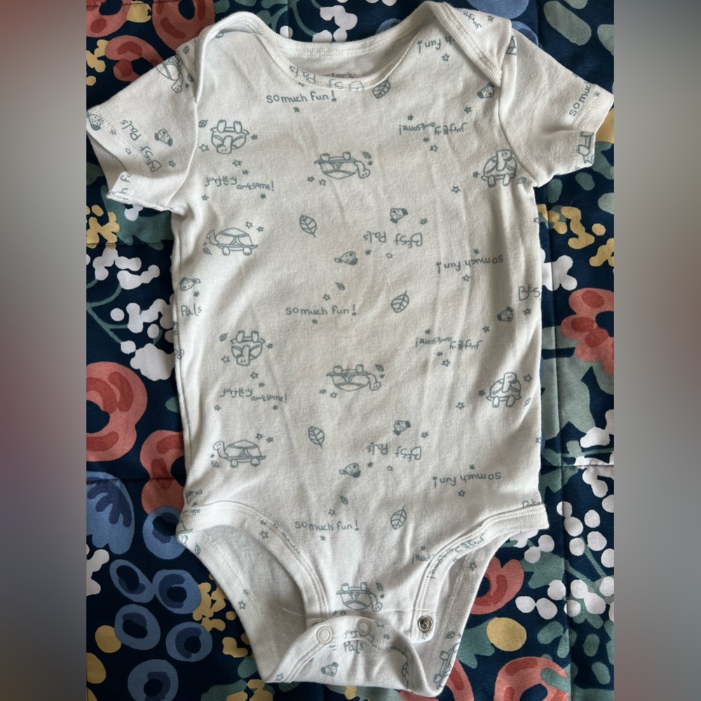 Carters turtle onesie. Color white and light gray with turtle print all around.